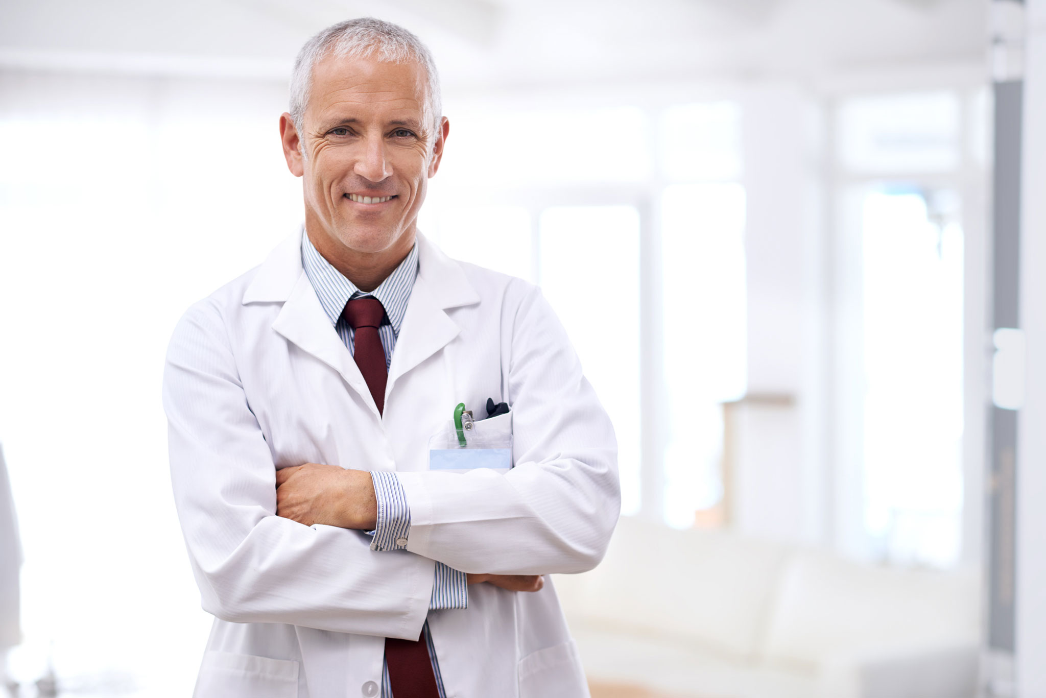 Portrait of a mature doctor standing with his arms folded